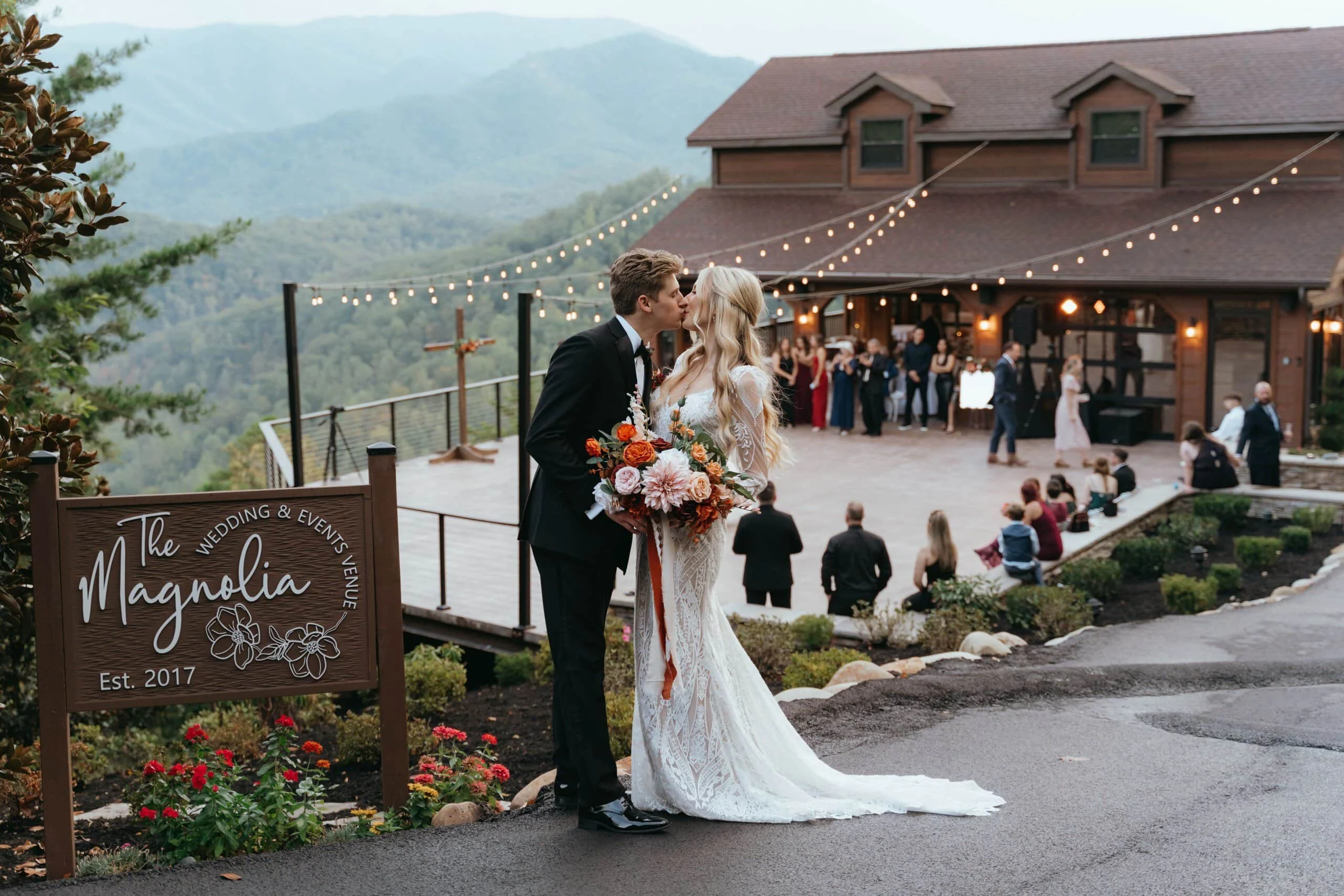 Bride and groom kissing at a mountain view wedding venue in Pigeon forge , Tennessee during their outdoor ceremony reception at Magnolia